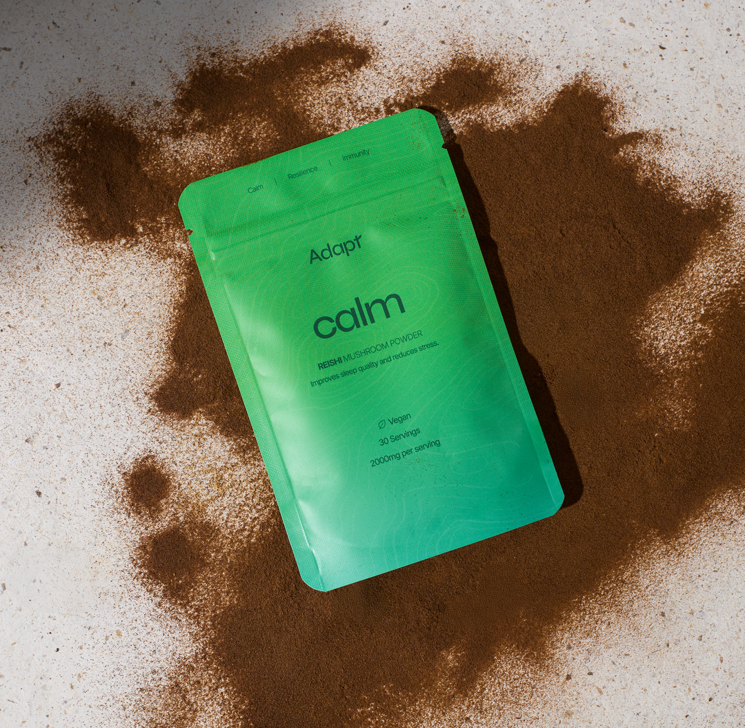 Adapt Reishi Packaging on a surface, with Reishi Powder beneath